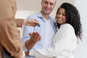 casal recebendo a chave do imóvel de uma imobiliária