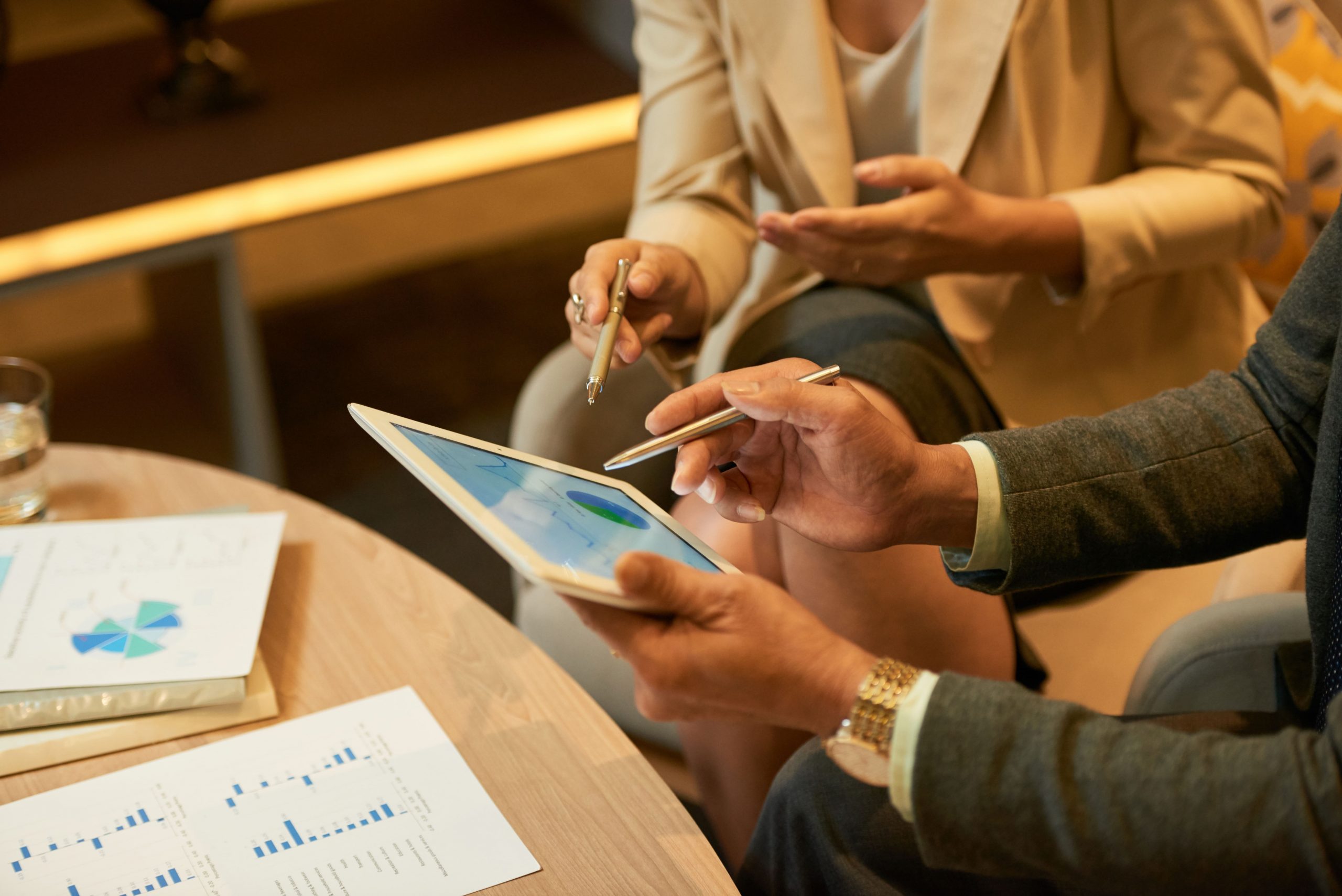 Homem e mulher empresários observando gráficos na tela do tablet após usar ferramenta de auditoria